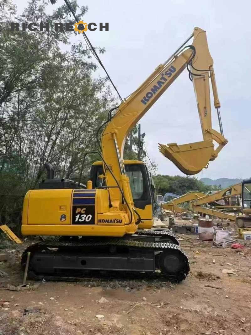 Side profile of a 2023 Komatsu PC130-8 excavator showing the boom and arm, 500 hours, $16,667